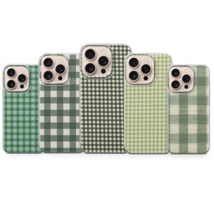 Puede incluir: Cinco fundas para teléfono con un patrón de cuadros verdes. Las fundas varían en tonos de verde, de claro a oscuro, y tienen protectores de lente de cámara transparentes. Las fundas están dispuestas en una fila, mostrando las diferentes variaciones de color.