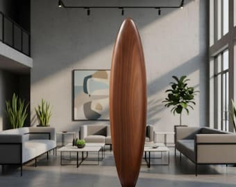 May include: A tall, smooth, dark brown wooden sculpture with a vertical, elongated, almond-shaped form. The object stands upright on a circular wooden base, featuring a polished finish that highlights the natural grain patterns of the wood.