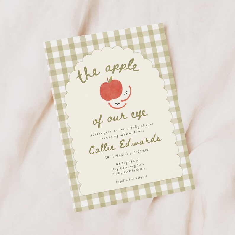 May include: A rectangular baby shower invitation card featuring a sage green and white gingham border. The center has a scalloped cream-colored panel with a red apple illustration and the text: the apple of our eye, please join us for a baby shower honoring mama-to-be Callie Edwards, SAT | MAY 23 | 11:00 AM, 123 Any Address, Any Place, Any State, Kindly RSVP to Callie, Registered on Babylist.