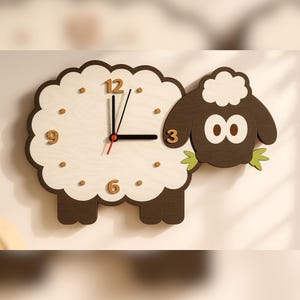 Pode incluir: Um relógio de parede em forma de ovelha com corpo de madeira clara e cabeça castanho-escura. O mostrador apresenta os números 3, 6, 9 e 12 em castanho-escuro, com ponteiros pretos para horas e minutos e um ponteiro vermelho. A ovelha segura folhas verdes.
