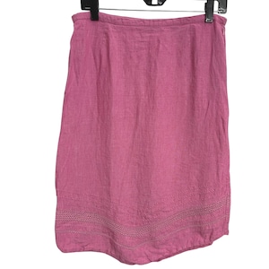 May include: A knee-length skirt in a solid dusty rose pink color. The garment features a straight silhouette with a side zipper closure and a decorative horizontal band of openwork crochet detailing near the bottom hemline, adding texture.