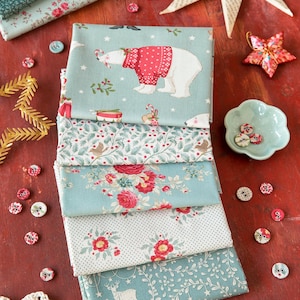 May include: A stack of five folded fabric pieces in shades of sage green, featuring patterns of polar bears in red sweaters, holly berries, red roses, and deer. The fabric is surrounded by scattered round buttons and decorative paper stars.