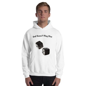 以下が含まれることがあります： 「God Doesn't Play Dice」の文字と、白いドットが付いた2つの黒いサイコロがプリントされた白いパーカー。 サイコロはパーカーのポケットの前に配置されています。