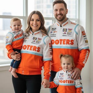 May include: A family of four wearing matching white, orange, and blue racing jackets with the word "HOOTERS" prominently displayed. The jackets have various sponsor logos. The family is smiling and posing for a photo.