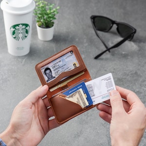 Leather ID wallet open on a desk with cards and coffee cup in the background