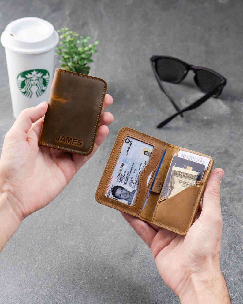 Two leather wallets in cognac and espresso displayed together on a gray surface