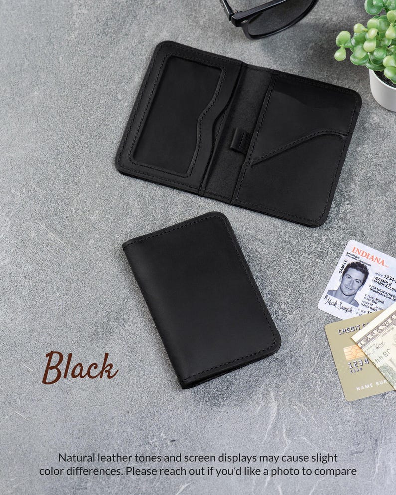 Black leather minimalist wallet with ID window and card slots on a gray background