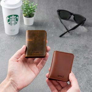 Person holding espresso leather wallet and showing size in hand