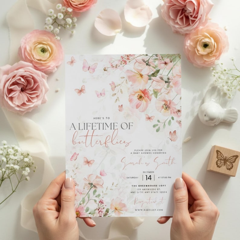 May include: A baby shower invitation with a floral and butterfly design. The invitation features the text "Here's to a lifetime of butterflies" and event details. Soft pink and white colors are used throughout the design.