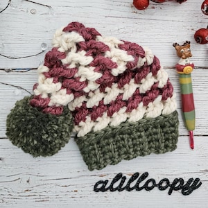 May include: A crocheted hat with a burgundy and white striped pattern and a green pom-pom. The hat has a green crocheted brim.