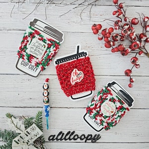 May include: Three crocheted coffee cup cozies with festive Christmas designs. The cozies are red and green with white accents. The text on the cozies reads "Merry Christmas ya futhy animal", "Oh fudge!" and "Always on the Naughty List".