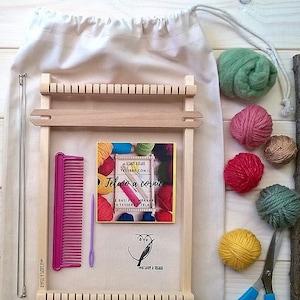 May include: A wooden loom with a small book titled "Telaio a cornice" and a bag of yarn. The yarn is in various colours, including green, pink, red, brown, and yellow. There are also a comb, a needle, and scissors.