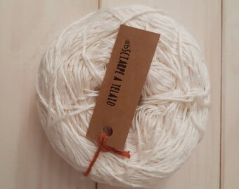 May include: A ball of white yarn with a brown tag that reads "S.B.S.CIARPE A TELATO".