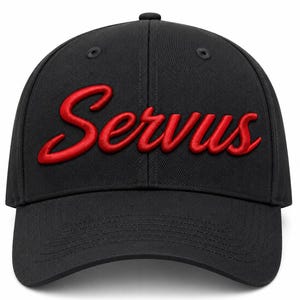 May include: A black baseball cap featuring the word Servus embroidered in a raised, bright red script font across the front panels. The cap has a structured crown, a curved brim with visible stitching, and eyelets on the top panels for ventilation.