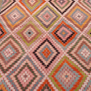May include: A colorful rug with a geometric diamond pattern. The rug features a repeating design of diamonds in shades of pink, orange, green, and blue, with black accents. The rug is likely made of woven fabric.