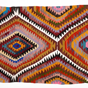 K&ouml;nnte beinhalten: Ein rechteckiger, handgewebter Teppich mit geometrischem Design. Der Teppich weist ein Rautenmuster in Rot-, Orange-, Gelb-, Braun-, Blau- und Wei&szlig;t&ouml;nen auf. Die Kanten sind mit einem wei&szlig;en Rand versehen. Der Teppich ist wahrscheinlich aus Wolle oder einem &auml;hnlichen Material.