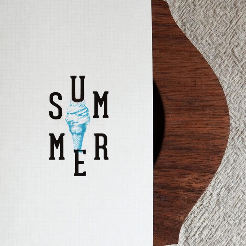 May include: A white rectangular card with a faint grid pattern features the black text SUMMER arranged vertically and horizontally around a central light blue watercolor illustration of a soft serve ice cream cone in the middle of the word.