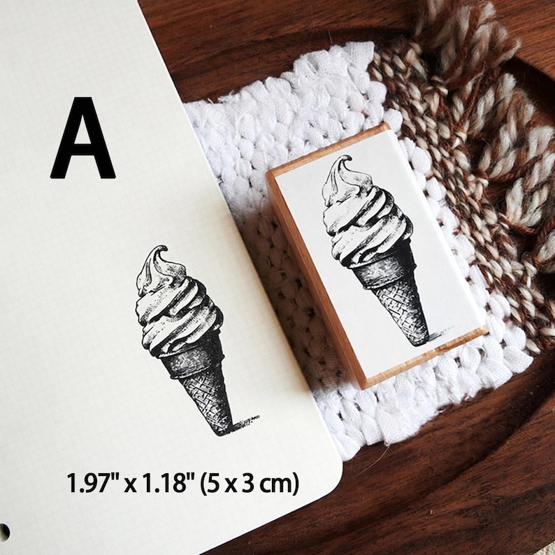May include: A rectangular wooden rubber stamp featuring a black ink illustration of a soft serve ice cream cone. The stamp is labeled with the letter A and includes printed dimensions of 1.97 inches by 1.18 inches for the stamped image.