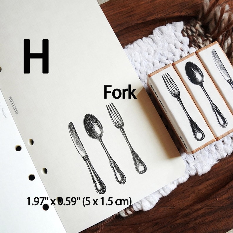 May include: Three rectangular wooden stamps featuring black ink illustrations of a knife, a spoon, and a fork. The stamps measure 1.97 inches by 0.59 inches. The paper shows the stamped images of the cutlery alongside the text H and Fork.