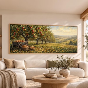 May include: A rectangular landscape painting in a wooden frame depicting an apple orchard with rows of trees laden with red fruit. A wooden cart and woven baskets filled with harvested apples sit on the grassy ground under a soft sky.