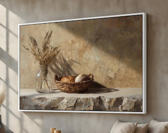 May include: A framed canvas print depicts a still life scene. A clear glass vase holds dried wheat stalks, and a woven basket contains two loaves of bread. The artwork is set against a textured, neutral-toned background.