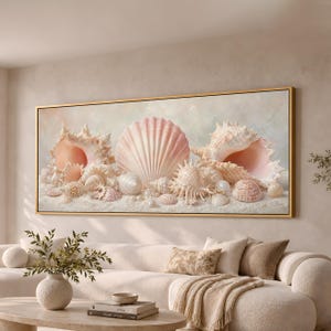 May include: A rectangular wall art print in a gold frame featuring a collection of pale pink and white seashells arranged on a sandy surface. The composition includes various spiral and fan-shaped shells with intricate textures and small white pearls.