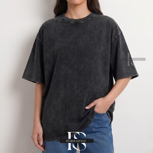 Pu&ograve; includere: Una maglietta grigio antracite oversize con un aspetto strutturato e lavato. La maglietta a maniche corte ha uno scollo tondo e una vestibilit&agrave; ampia. La modella indossa jeans blu. La maglietta &egrave; del marchio "IEMERASTYLE".