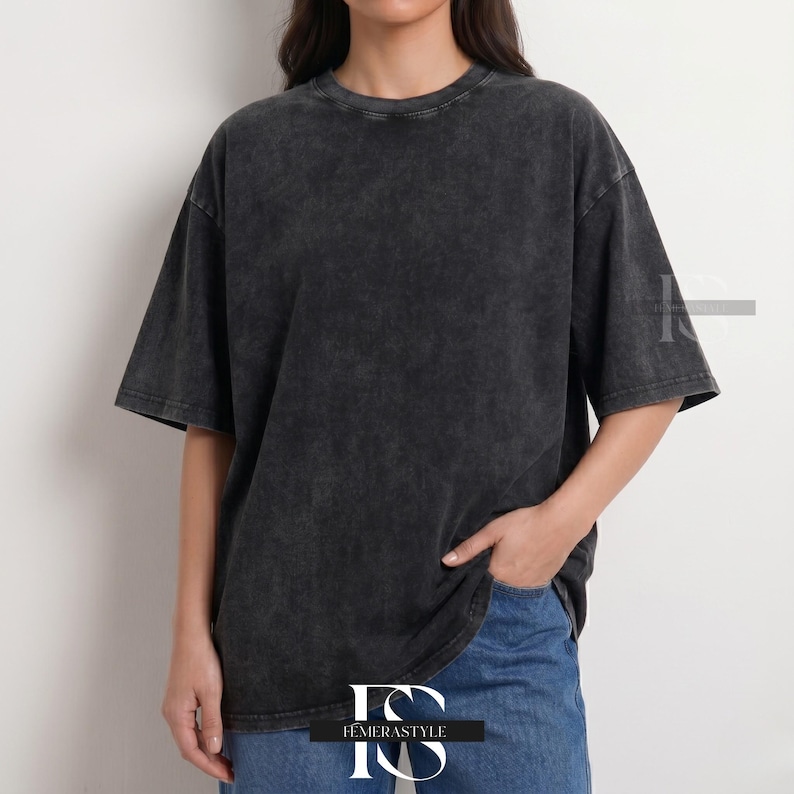 Pu&ograve; includere: Una maglietta grigio antracite oversize con un aspetto strutturato e lavato. La maglietta a maniche corte ha uno scollo tondo e una vestibilit&agrave; ampia. La modella indossa jeans blu. La maglietta &egrave; del marchio "IEMERASTYLE".