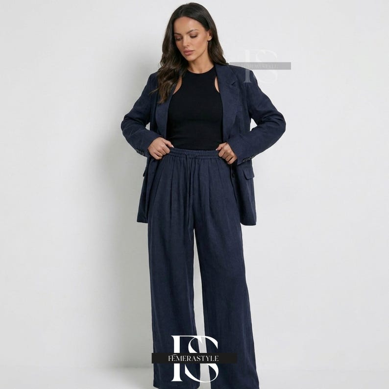May include: A dark navy blue blazer and matching wide-leg trousers set paired with a solid black sleeveless top. The blazer features a notched lapel and front pockets, while the trousers have a high-waisted design with a drawstring waistband.