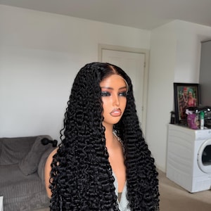 Puede incluir: Una taza de cerámica blanca con un asa negra y el texto "But First, Coffee" en un estilo manuscrito. La taza está sobre una superficie blanca. La taza mide aproximadamente 10 cm de alto.