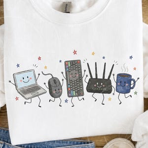 May include: A white crewneck sweatshirt featuring a graphic print of five anthropomorphic items: a laptop, a computer mouse, a mechanical keyboard, a Wi-Fi router, and a blue coffee mug, all surrounded by small colorful stars.