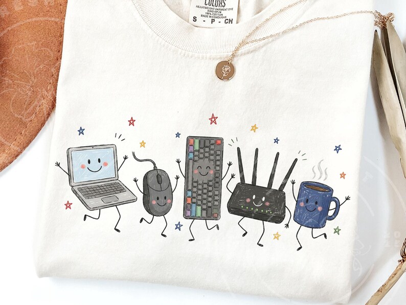 May include: A cream-colored t-shirt featuring a graphic print of five anthropomorphic tech items: a laptop, a computer mouse, a keyboard, a Wi-Fi router, and a blue coffee mug, all with smiling faces and limbs, surrounded by small colorful stars.