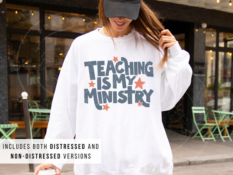 May include: White sweatshirt with the text "TEACHING IS MY MINISTRY" in blue and red. The sweatshirt includes both distressed and non-distressed versions. The image shows a person wearing the sweatshirt.
