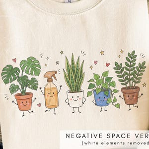 K&ouml;nnte beinhalten: Ein cremefarbenes Sweatshirt mit Rundhalsausschnitt und einer grafischen Illustration von f&uuml;nf anthropomorphen Topfpflanzen und einer Spr&uuml;hflasche. Jede Figur hat ein l&auml;chelndes Gesicht, Arme und Beine, umgeben von kleinen Herzen und Sternen.