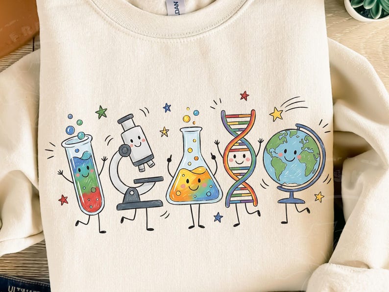 Puede incluir: Una sudadera de cuello redondo color crema con un estampado gr&aacute;fico colorido de cinco iconos cient&iacute;ficos antropom&oacute;rficos: un tubo de ensayo, un microscopio, un matraz Erlenmeyer, una doble h&eacute;lice de ADN y un globo terr&aacute;queo, todos con caras sonrientes.