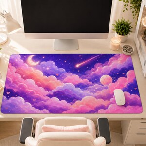 May include: A rectangular desk mat featuring a vibrant night sky illustration with pink and purple clouds, a crescent moon, a planet with rings, a shooting star, and small heart shapes scattered throughout the celestial scene.