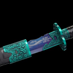 May include: A detailed close-up of a decorative sword. The blade has a blue and purple hue, with ornate floral designs on the teal hilt and scabbard. The handle is wrapped in black leather, and the scabbard is black with a geometric pattern.