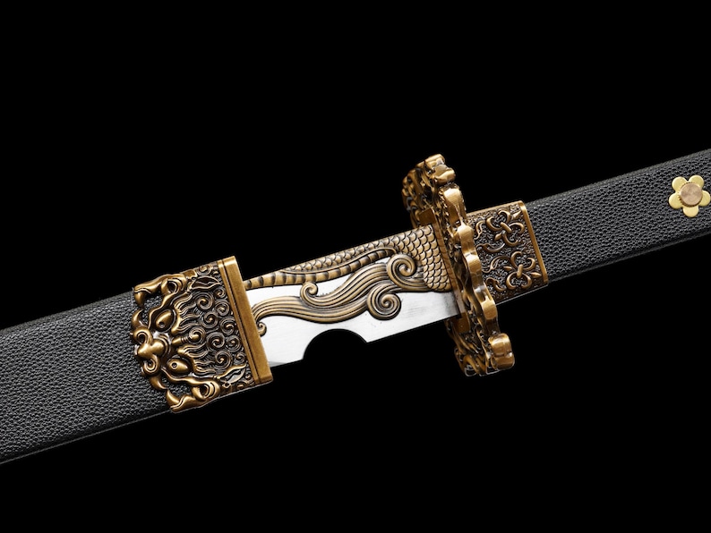 May include: Close-up of a decorative sword with a black handle and a silver blade. The hilt and guard are ornate, featuring gold-colored lion and dragon designs. A gold flower decorates the handle.