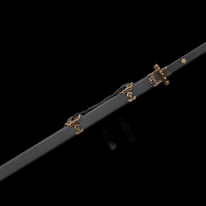 May include: A black sword with a decorative gold hilt and accents. The sword is in a black scabbard with gold embellishments. The blade is not visible. The sword is displayed against a black background.