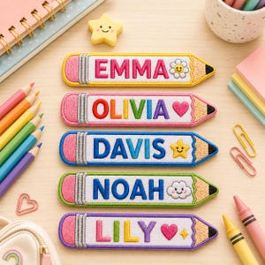 May include: Five rectangular embroidered pencil-shaped patches featuring the names EMMA, OLIVIA, DAVIS, NOAH, and LILY. Each patch has a pink eraser end, a white center with colorful lettering, and a tan pencil tip with a black lead point.