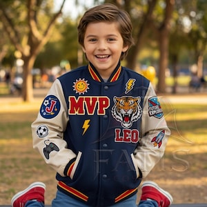 May include: A navy blue varsity jacket with cream-colored sleeves, featuring patches of a sun, lightning bolt, tiger head, and rocket. The text MVP and LEO are displayed on the front, along with icons of a soccer ball, game controller, and planet.