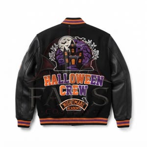 Könnte beinhalten: Eine schwarze Collegejacke mit langen schwarzen Ärmeln und einem Rückenmotiv aus einem Spukhaus, einem Vollmond und Fledermäusen. Der Text lautet HALLOWEEN CREW und NIGHTMARE ACADEMY. Die Jacke hat orange und violett gestreifte Rippbündchen an Kragen, Ärmeln und Saum.