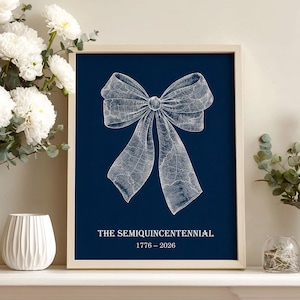 Könnte beinhalten: Gerahmter Kunstdruck mit einer detaillierten weißen Schleifenillustration auf marineblauem Hintergrund. Der Text "THE SEMIQUINCENTENNIAL 1776 - 2026" ist darunter gedruckt. Das Kunstwerk steht auf einem weißen Kaminsims, neben weißen Blumen und Grün.
