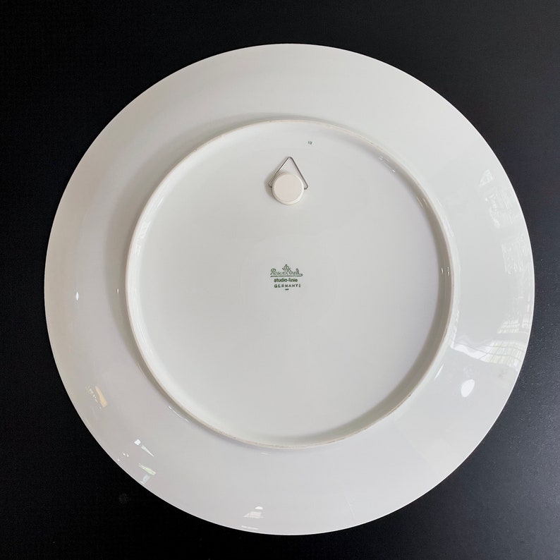 Puede incluir: Plato de cer&aacute;mica blanco con un logotipo verde y blanco que dice "Rosenthal Studio-Line Germany" en la parte posterior.