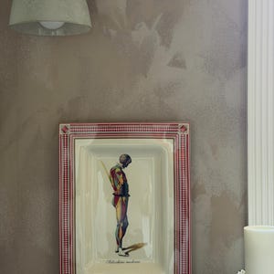 May include: A rectangular ceramic serving platter featuring a central illustration of a figure in a colourful harlequin-style costume. The border has a red and white geometric pattern. The text "Arlecchino moderno" is printed at the bottom.