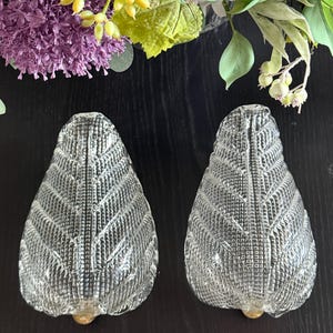 May include: A white ceramic mug with a black handle and the text "But First, Coffee" in a black, bold font. The mug is on a white surface. The mug is approximately 4 inches tall.