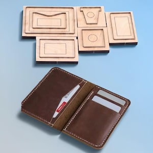 Peut inclure: Portefeuille en cuir marron ouvert, avec des coutures blanches, contenant des cartes. Au-dessus, des formes découpées en bois pour la fabrication d'articles en cuir sont disposées sur un fond bleu.