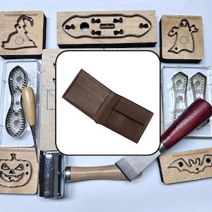 May include: A brown leather bifold wallet with a textured surface, featuring multiple interior card slots and a central bill compartment, displayed against a background of various metal leatherworking cutting dies and tools.