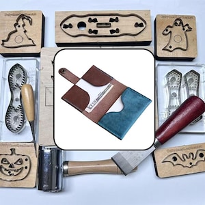 May include: A bi-fold leather wallet featuring a brown exterior, a blue interior pocket, and a snap button closure. The wallet is open and contains a fifty-dollar bill. It is surrounded by various metal leathercraft cutting dies and tools.