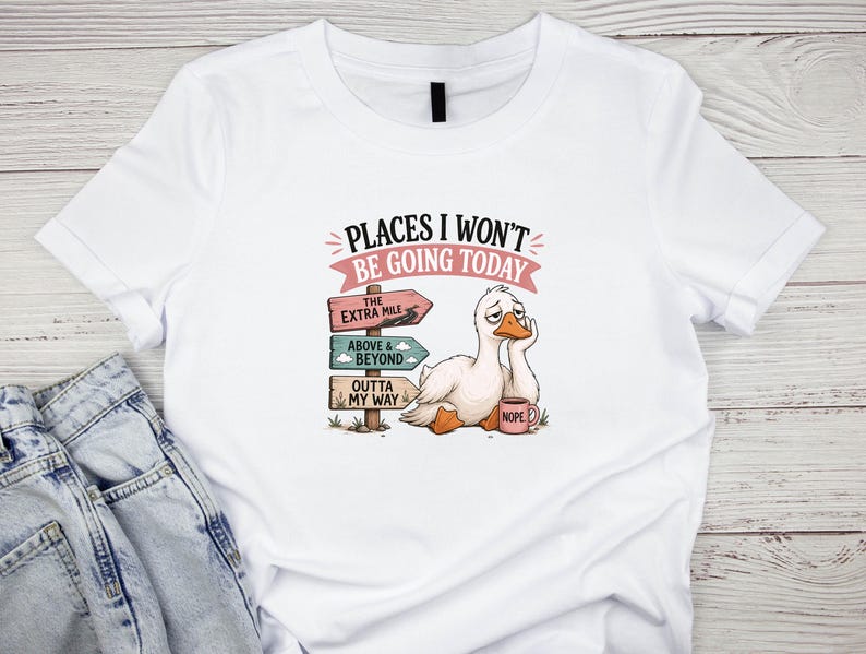 May include: A white t-shirt featuring a graphic of a tired white duck holding a pink mug labeled NOPE. Next to the duck is a wooden signpost with three signs reading THE EXTRA MILE, ABOVE & BEYOND, and OUTTA MY WAY, with the text PLACES I WON'T BE GOING TODAY.